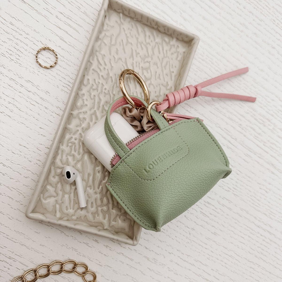 Louenhide Gina Bag Charm Sage Green shaped like a mini handbag with pink strap detail