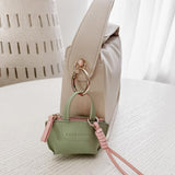 Louenhide Gina Bag Charm Sage Green shaped like a mini handbag with pink strap detail