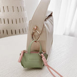 Louenhide Gina Bag Charm Sage Green shaped like a mini handbag with pink strap detail