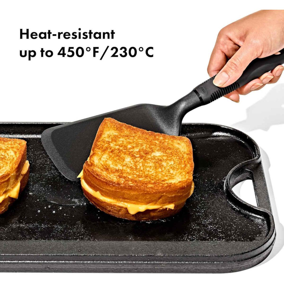 Hand using a spatula to lift a grilled sandwich from a black griddle  | Minimax