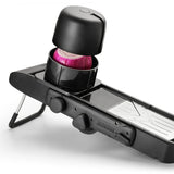 Alligator Mandoline Slicer Black, close-up of hand pressing safety holder with onion on slicing surface