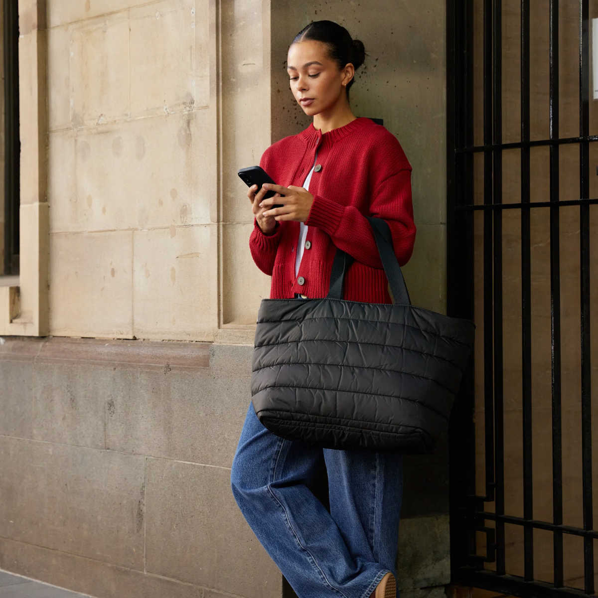 Base Supply Cloud Take It Base Black 56x35x18cm – lifestyle view, carried by a woman in a red cardigan.