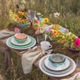Bordallo Pinheiro Flora Bowl Blue 17cm – Blue floral-shaped bowl on a rustic outdoor table with flowers