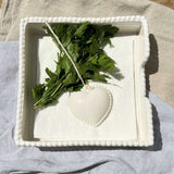Ceramic Heart Napkin Holder White displayed with blue patterned napkins on wooden table