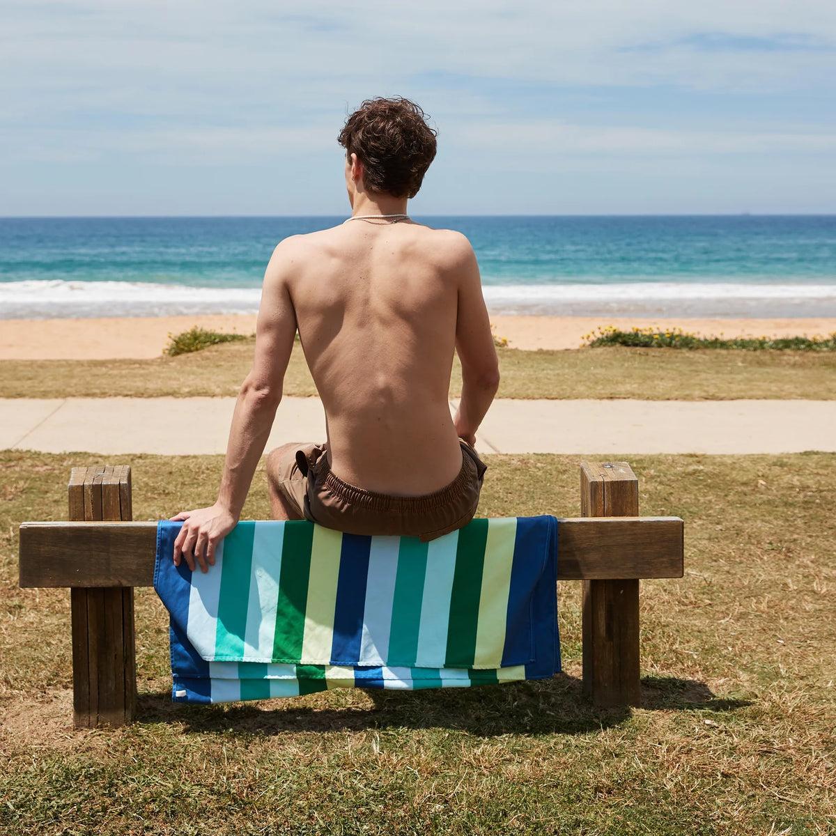 Dock & Bay Summer Collection Beach Towel Cool Lagoon 90x160cm | Minimax - with a man facing the beach