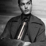 Frank Green Ceramic Reusable Bottle Shadow Chrome 1L – lifestyle shot held by model in grayscale