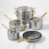 GreenPan Stanley Tucci Stainless Steel Cookware Set 6 Piece with gold handles, glass lids, and non-stick frying pans on marble surface