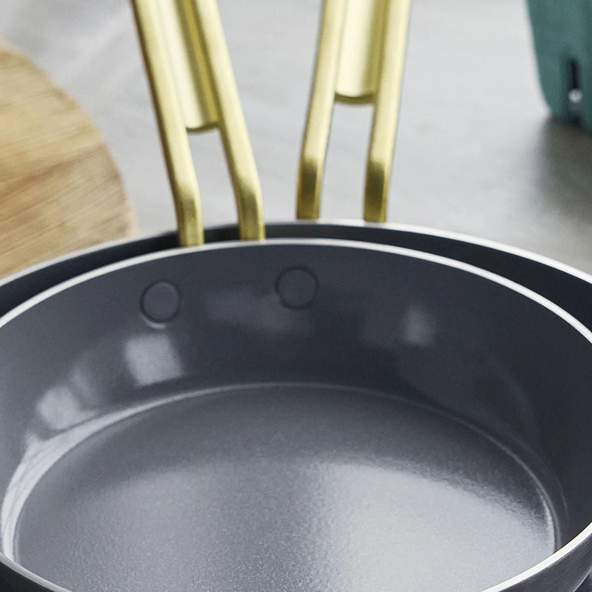 GreenPan Stanley Tucci Stainless Steel Frypan Set 20cm & 26cm with gold handles stacked together on white background