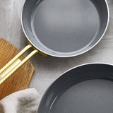 GreenPan Stanley Tucci Stainless Steel Frypan Set 20cm & 26cm with gold handles stacked together on white background