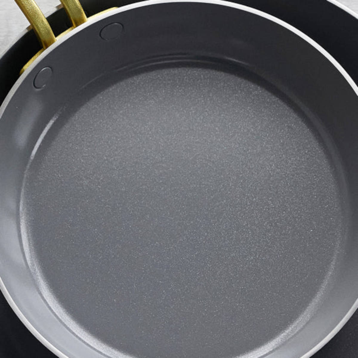 GreenPan Stanley Tucci Stainless Steel Frypan Set 20cm & 26cm with gold handles stacked together on white background