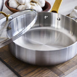 GreenPan Padova Stainless Steel Sauté Pan 24cm – angled view with garlic in background