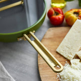 GreenPan Stanley Tucci Pan Junior Green – close-up gold handle detail with cheese on board