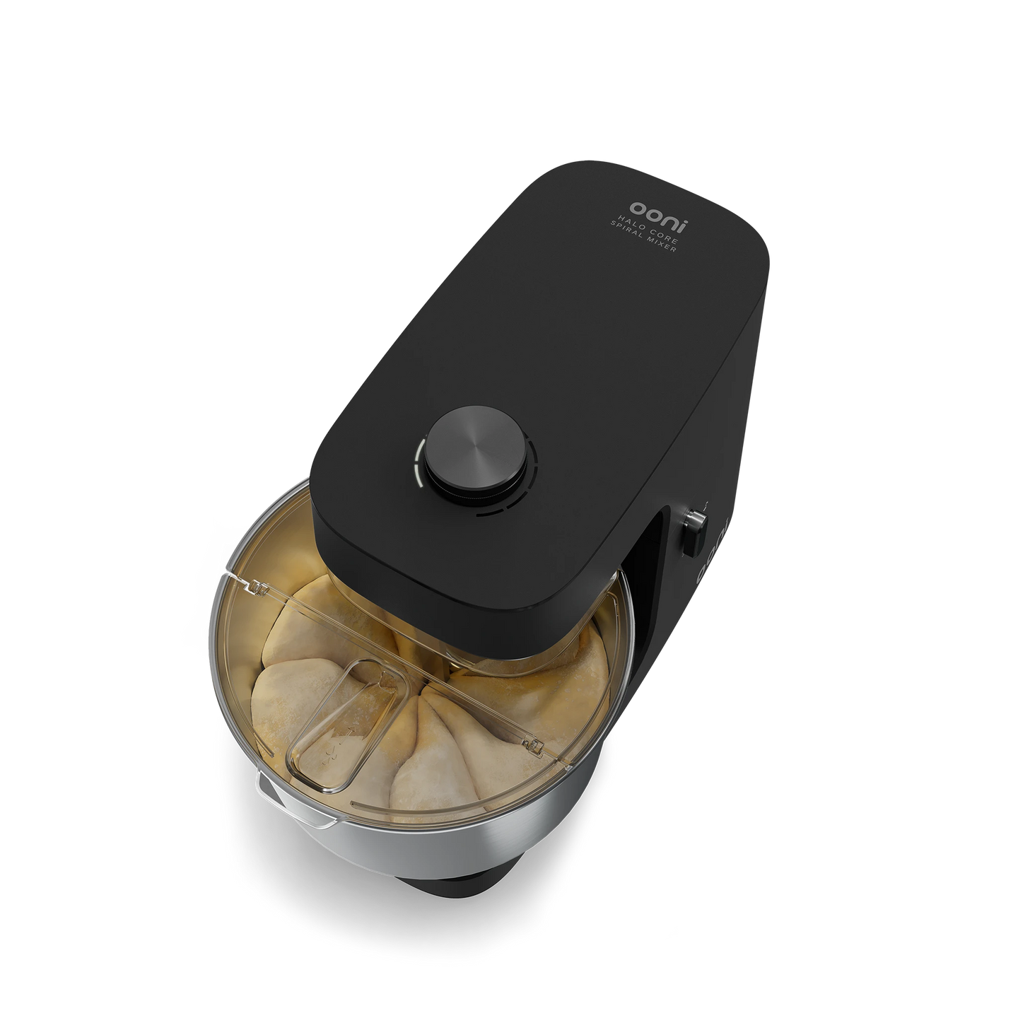 Angled top-down view of the Ooni Halo Core Spiral Mixer in Foundry Black kneading pizza dough in the stainless steel bowl with splash guard.
