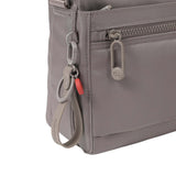 Close-up of the bag's front corner highlighting the smooth zip closures, signature Hedgren hardware, and detachable key leash with red accent.
