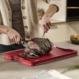 Joseph Joseph Cut & Carve Plus Multi-function Chopping Board Red XL with angled cutting surface, spikes, and juice-catching edges