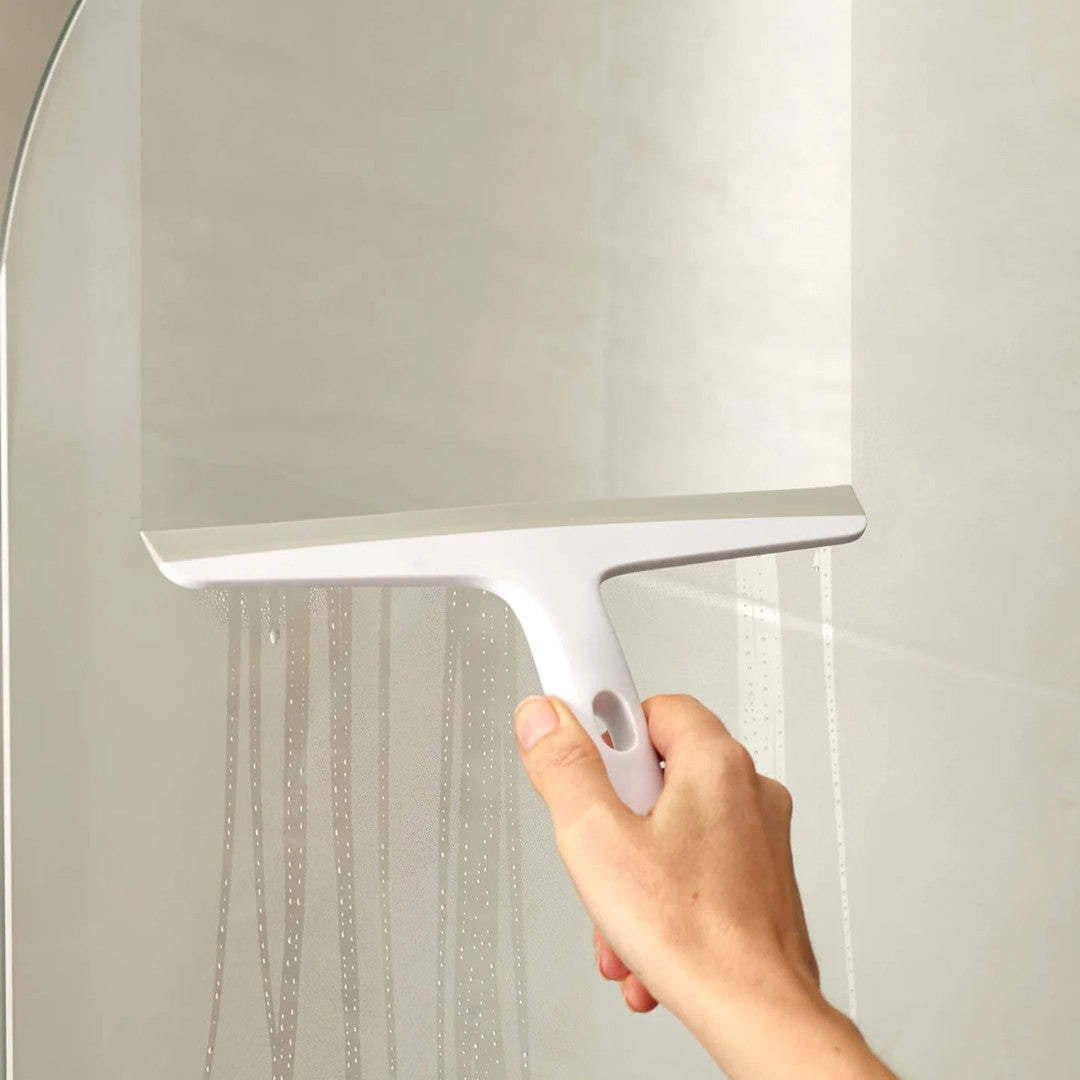 Squeegee in use clearing water from glass shower screen