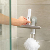 Hand placing squeegee onto wall-mounted hook in tiled shower