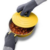 Joseph Joseph Pinch gloves lifting lid of yellow pot filled with stew