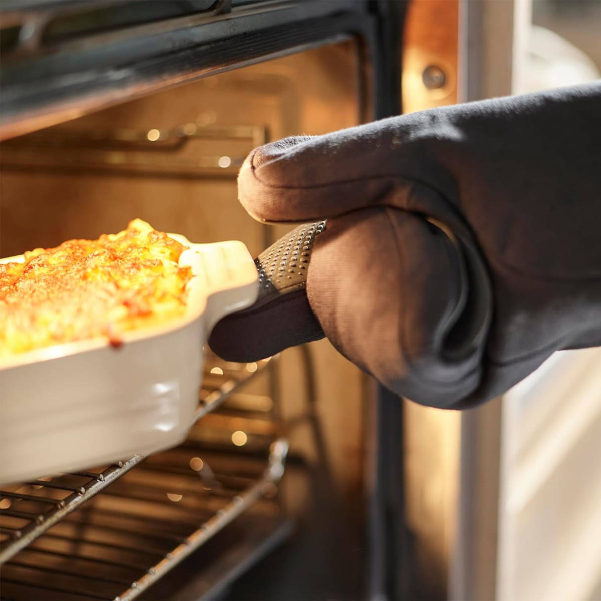 Close-up of Joseph Joseph Pinch glove gripping dish while removing from oven