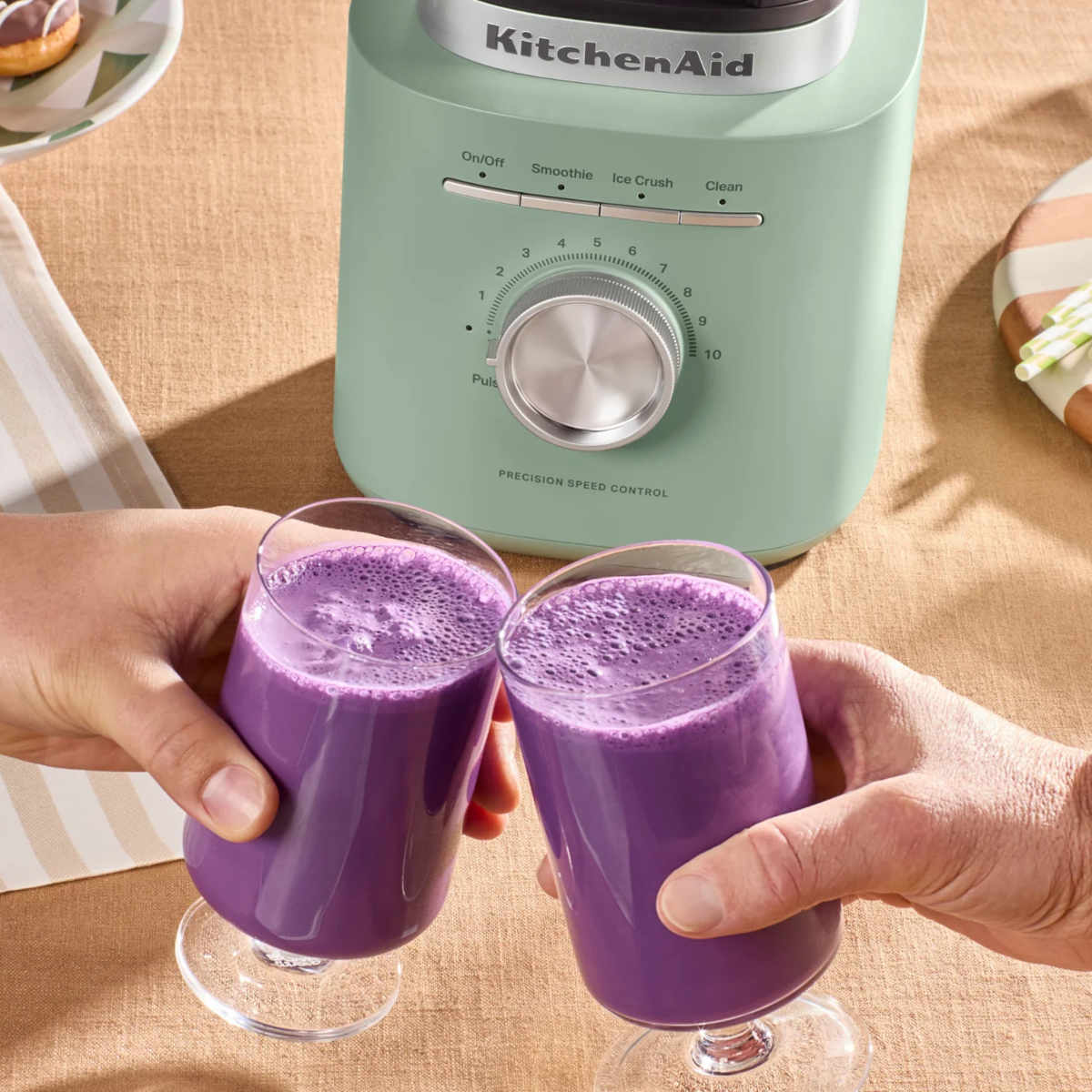 Close-up of the KitchenAid Pure Power Blender in Cardamom with two freshly blended purple smoothies being served.