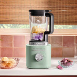 KitchenAid Pure Power Blender in Cardamom blending a vibrant smoothie with banana, berries, and milk on a kitchen countertop.