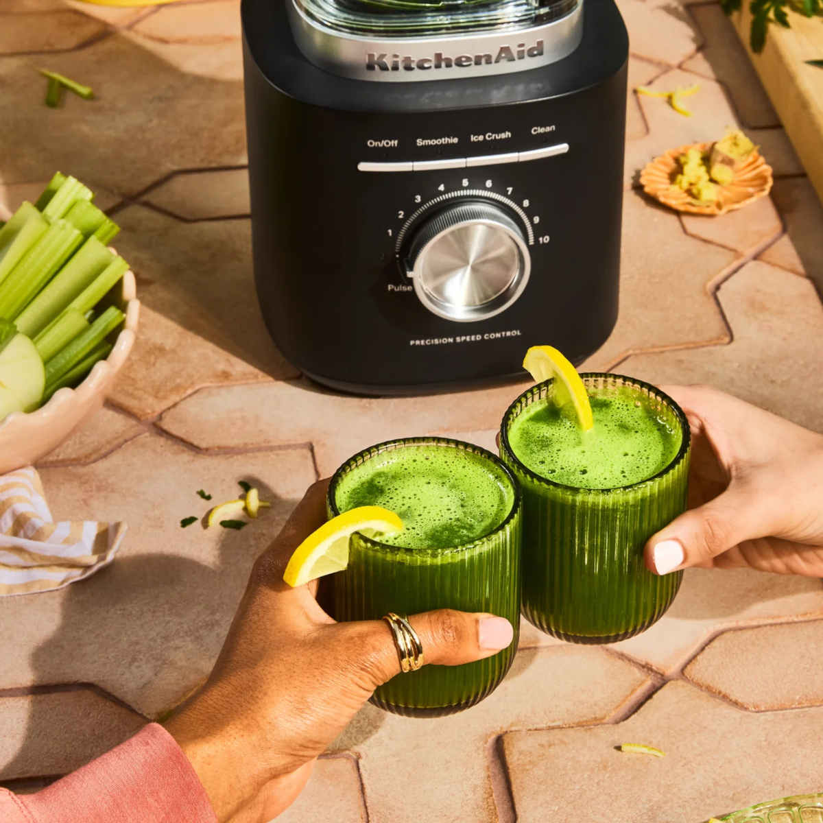 KitchenAid Pure Power Blender in Matte Black with fresh green smoothies served in glasses on an outdoor table.