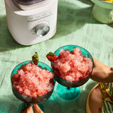 Close-up of the KitchenAid Pure Power Blender stainless steel blade crushing ice and frozen strawberries.