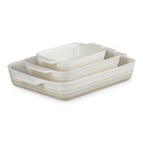 Top view of Le Creuset Heritage Rectangular Dish Meringue Set of 3 stacked together on white surface