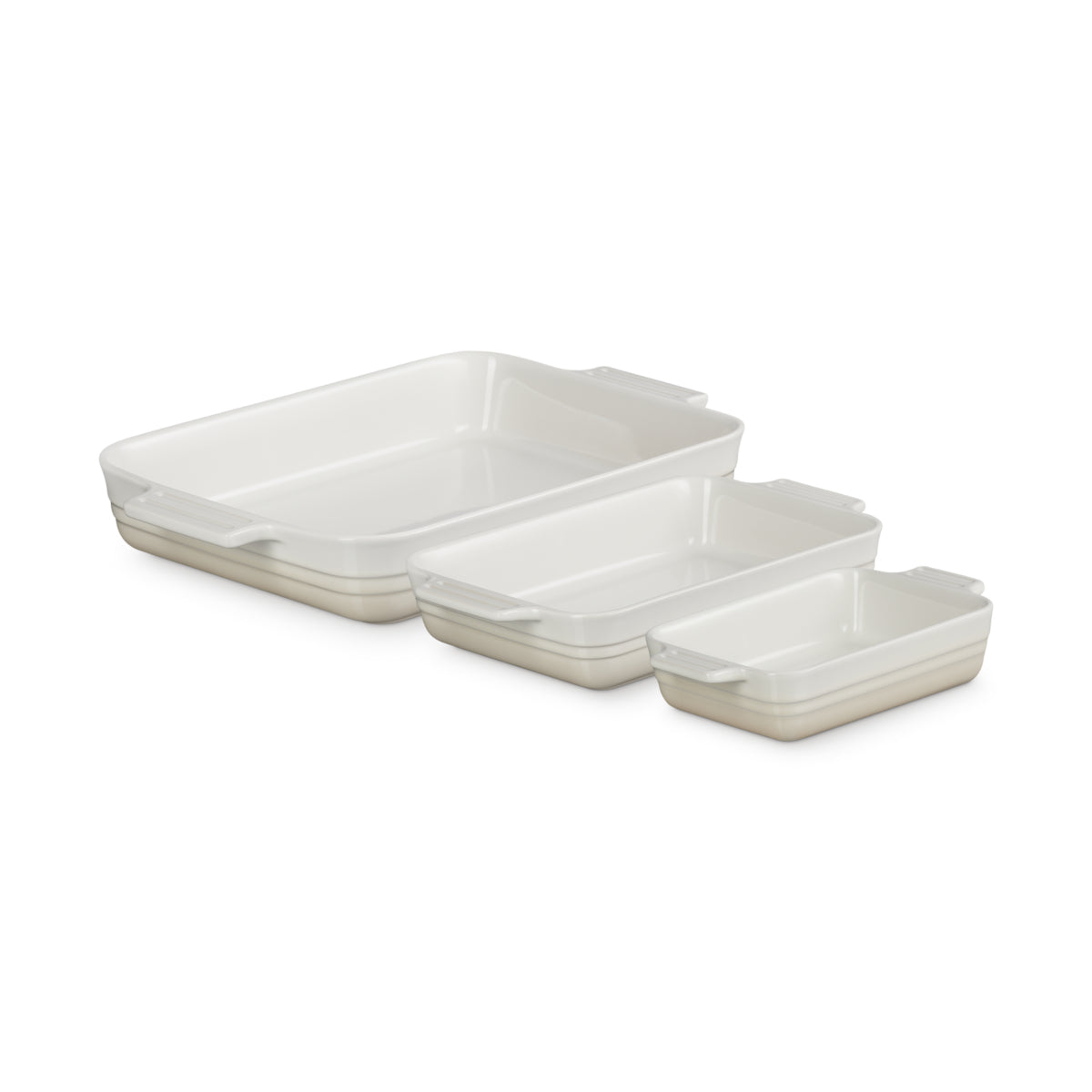 Angled view of Le Creuset Heritage Rectangular Dish Meringue Set of 3 nested on white