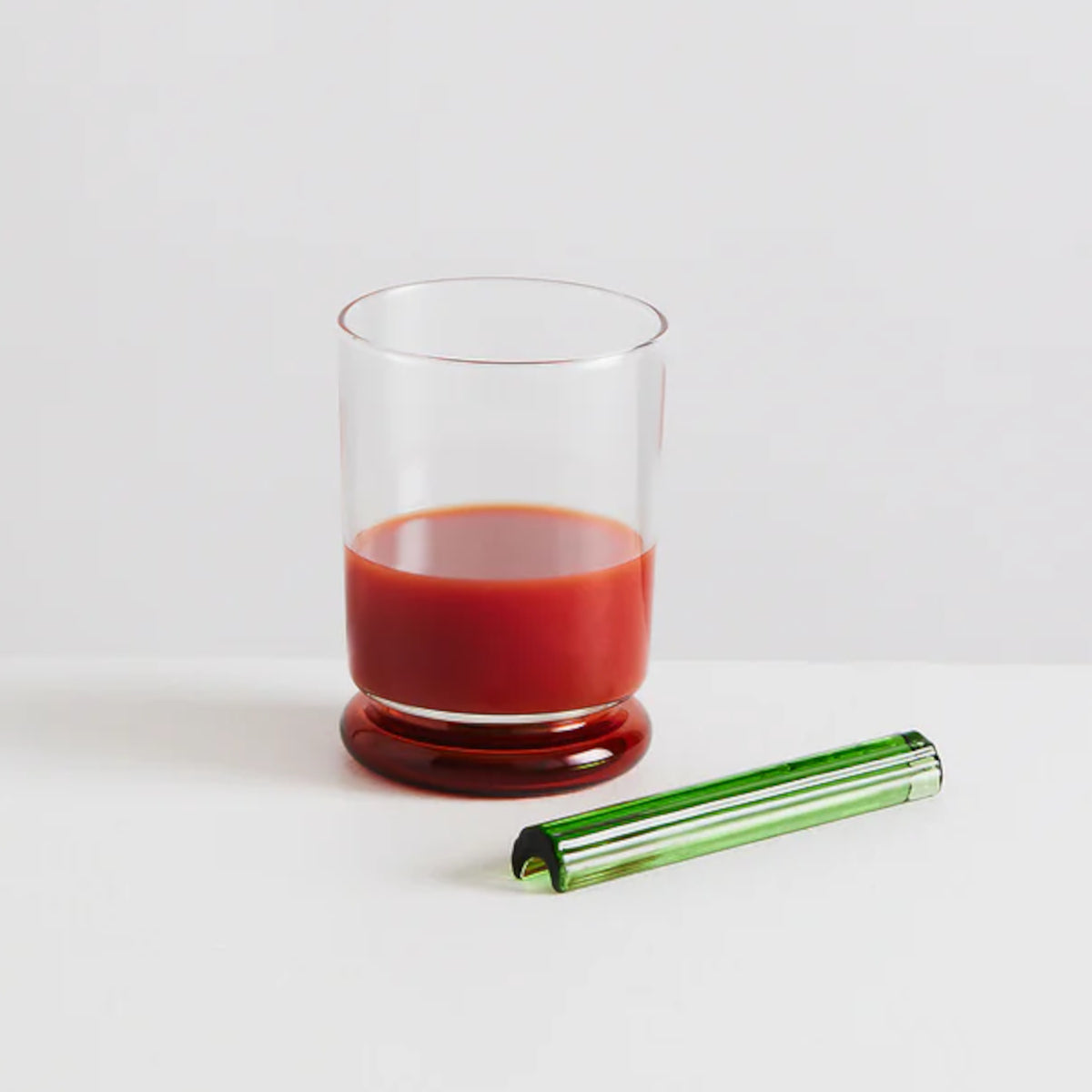 Maison Balzac Bloody Mary Cocktail Glass – styled with tomato juice and Tabasco bottle, highlighting its playful red base and green stirrer