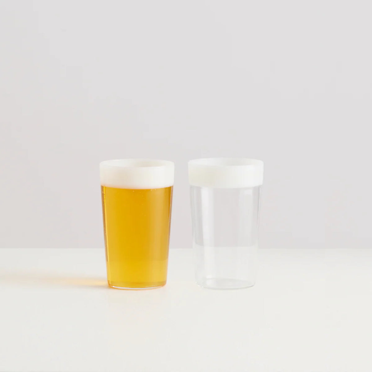 Maison Balzac Ceres Beer Glasses 375ml (Set of 2) – one filled with beer, one empty on white surface