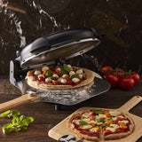 MasterPro Ultimate Pizza Oven Black open with pizza on peel, tomatoes and basil on table