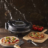 Lifestyle photo of MasterPro Ultimate Pizza Oven Black with cooked pizzas on wooden table