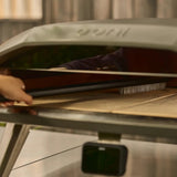 Ooni Pizza Oven Brush Short, angled view of compact pizza oven brush with wooden handle and metal scraper