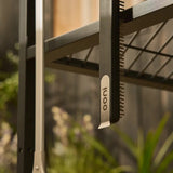 Ooni Pizza Oven Brush Short, angled view of compact pizza oven brush with wooden handle and metal scraper