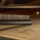 Ooni Pizza Oven Brush Short, angled view of compact pizza oven brush with wooden handle and metal scraper