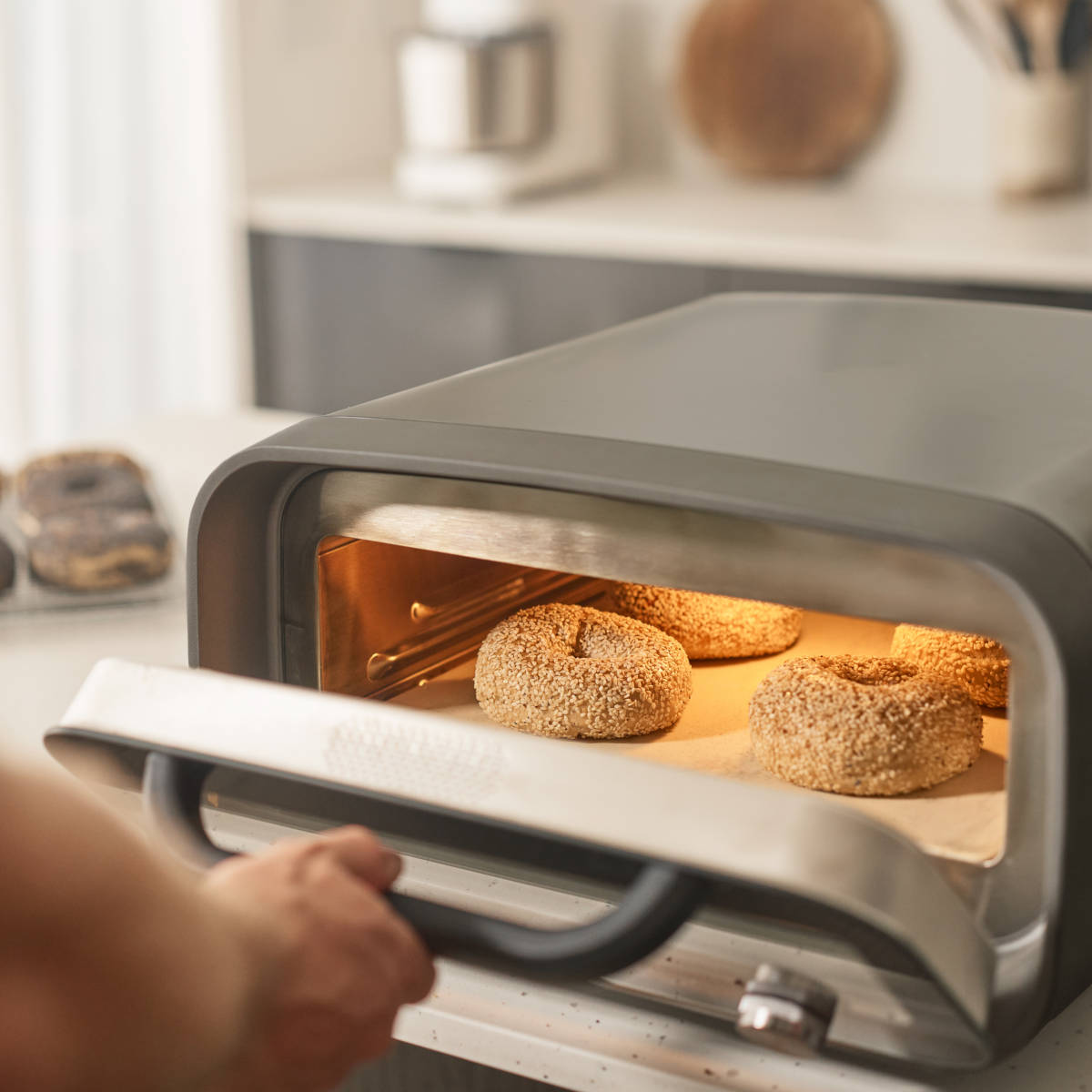 Ooni Volt 2 Pizza Oven Charcoal – angled side view with orange-lit interior at 450 degrees