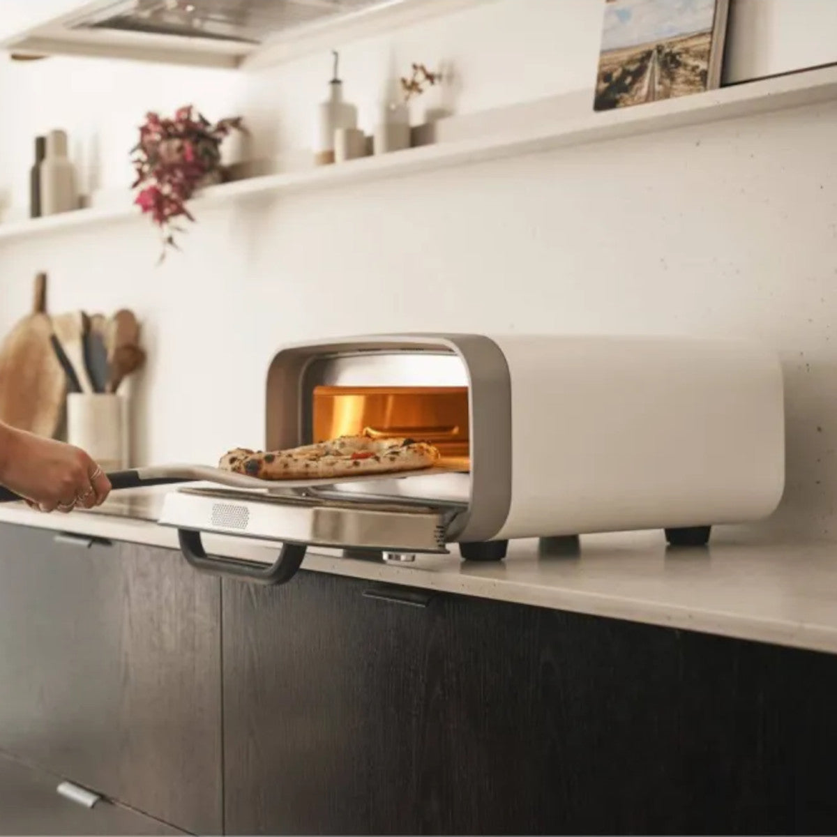 Ooni Volt 2 Pizza Oven Polar White – kitchen counter scene with pizza sliding inside