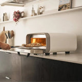 Ooni Volt 2 Pizza Oven Polar White – kitchen counter scene with pizza sliding inside