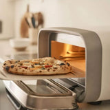 Ooni Volt 2 Pizza Oven Polar White – inserting fresh pizza into oven on baking peel