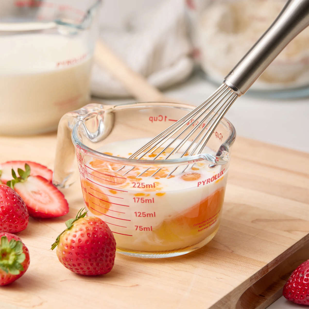 Pyrolux Measuring Jug 2 Cup (500ml) – whisk in jug with milk, eggs and other ingredients nearby