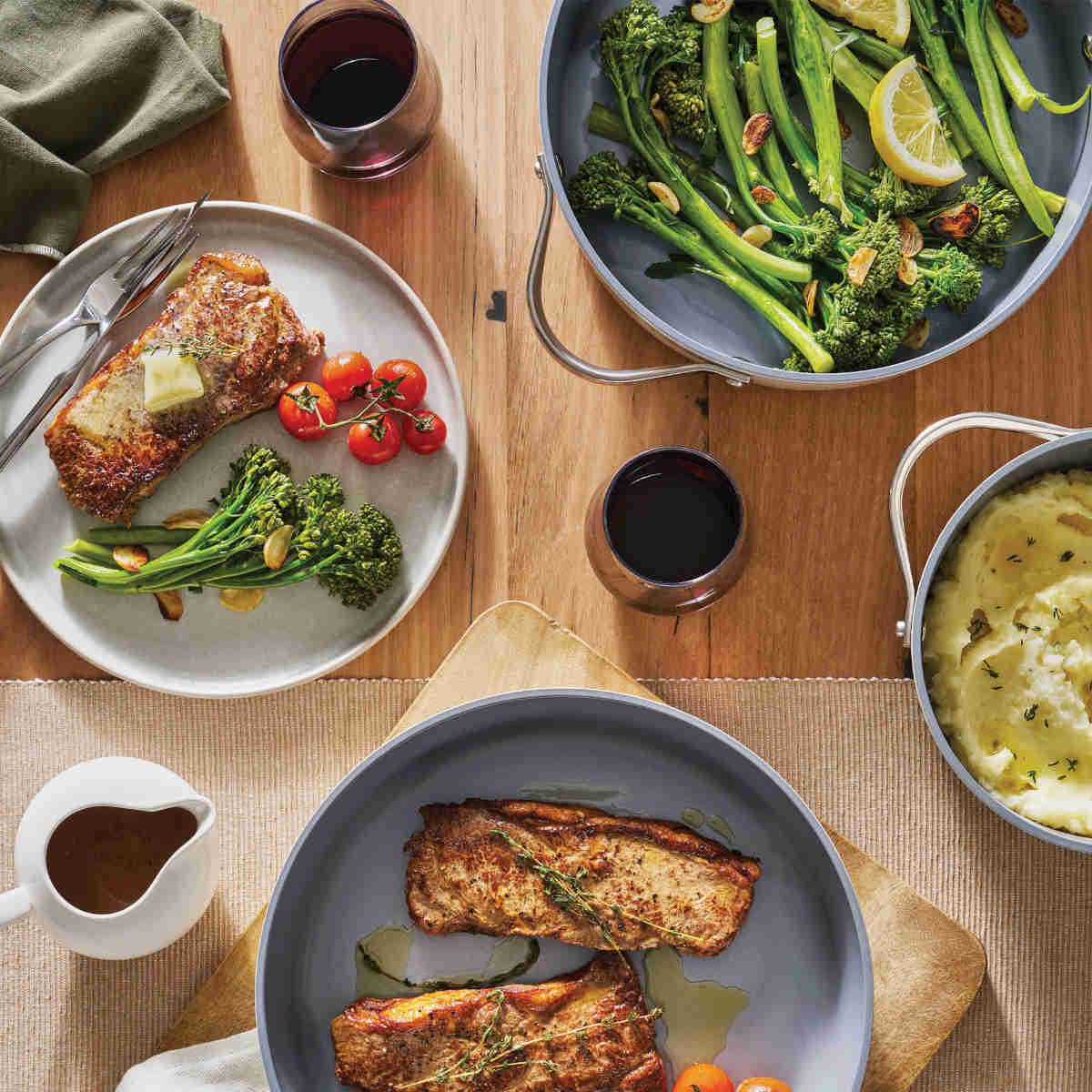 Pyrolux NEXGEN Casserole Denim 24cm (4.4L), lifestyle shot of plated meals and cookware on wooden dining table setting