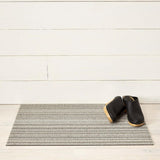 Chilewich Utility Mat Skinny Stripe Birch 61x91cm | Minimax - with a black boots