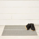 Chilewich Utility Mat Skinny Stripe Birch 61x91cm | Minimax - with a black boots