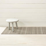 Chilewich Utility Mat Skinny Stripe Birch 61x91cm | Minimax - with a white stool