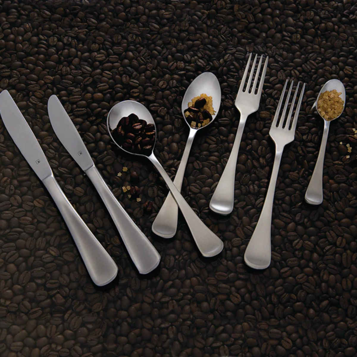 Tablekraft Elite Soup Spoon – part of Elite cutlery set with knives, forks, and spoons displayed on coffee beans