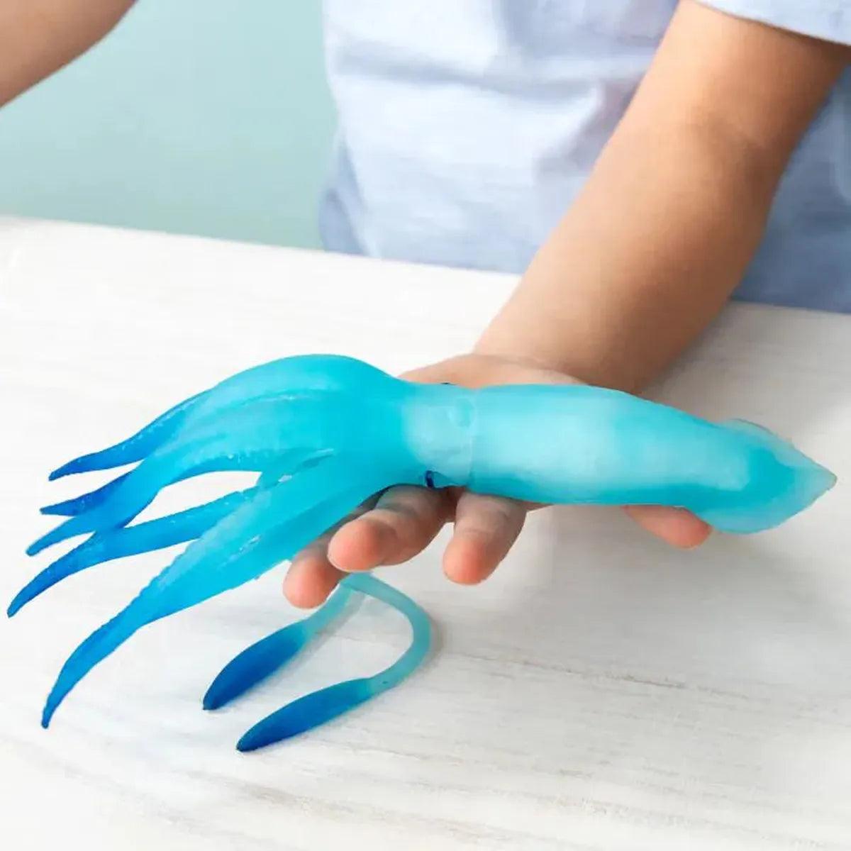 Rex London Glow in the Dark Squishy Squid Toy | Minimax  - A kid holding the toy