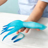 Rex London Glow in the Dark Squishy Squid Toy | Minimax  - A kid holding the toy